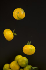Falling tangerines on a black background.