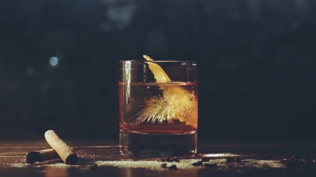Alcohol cocktail with ice cubes on a bar