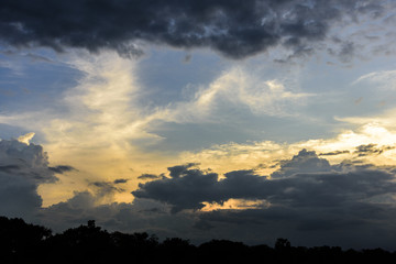 Cloudy sky group with condensation and forest in evening before sunset and raining.