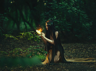 A fabulous, forest nymph with long hair found a flaming, fiery flower, with which little...