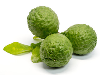 close up group of fresh bergamot with green leaves isolated on white background. benefits of bergamot for beauty and health concept
