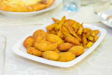 Fries served on a platter. Fried potatoes in a restaurant. Unhealthy but satisfying food.