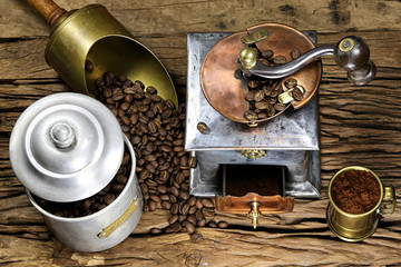 vintage coffee grinder with manufacture roasted Indonesian Arabica coffee beans on rustic wooden background