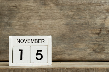 White block calendar present date 15 and month November on wood background