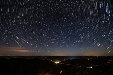 Fototapeta premium Star Trails Over Rural Town