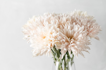 Vase with white chrysanthemum on a table of wooden planks