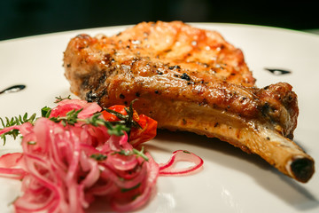 Grilled steak on plate with red onion
