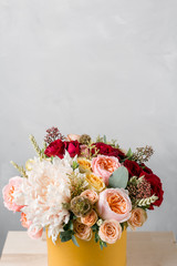 Flowers in round luxury present box. Bouquet of mixed flowers in yelow paper box.