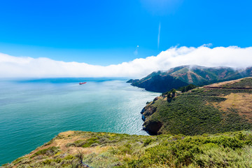 Coast at Golden Gate Bridge in clouds on a beautiful summer day  - Panoramic view from Battery Spencer - San Fancisco Bay Area,  Golden Gate National Recreation Area, California, USA