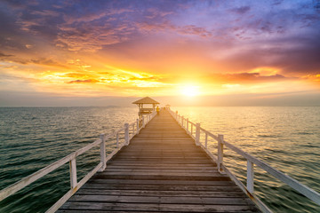 Fototapeta na wymiar Wooden bridge in the sea at sunset