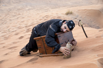 black pirate in a desert with treasure box, fallen asleep protecting his treasure
