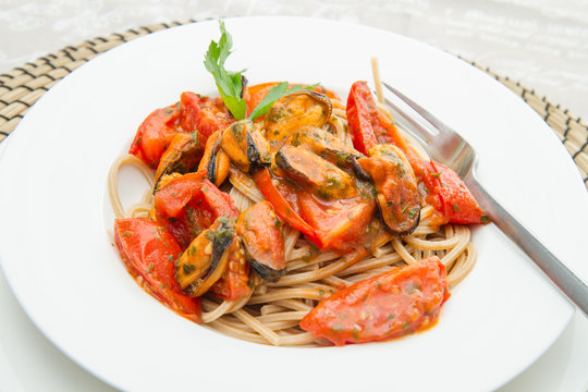 white dish with Pasta spaghetti , mussel and tomatoes