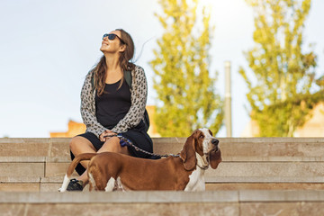 Passeio no parque com o cão Basset Hound em primeiro plano numa linda tarde sentada na escadaria...