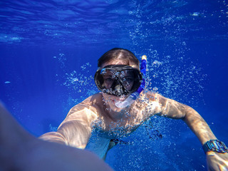 Underwater wide angle selfie of muscular swimmer with a lot of bulb