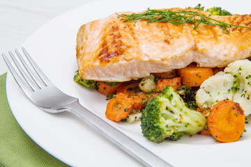 salmon fillet on a bed of broccoli, cauliflower and carrots