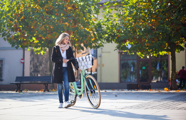 Autumn in the city, woman with retro bike