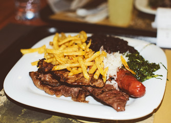 Junk food concept. French fries with rice and fried meat.