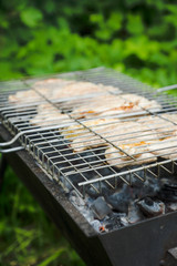 Chicken grilling on the brazier. Selective focus.