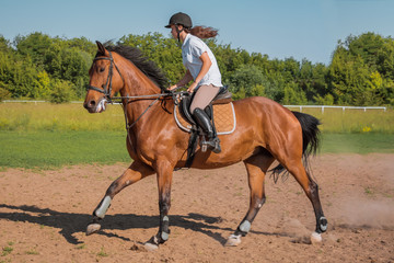 Girl goes astride a horse