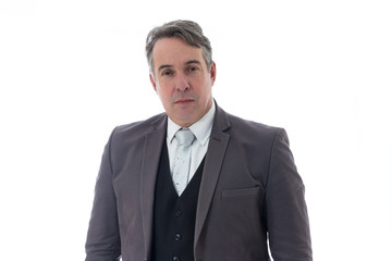 Gray haired man looks seriously. He has gray hair and social clothing..
