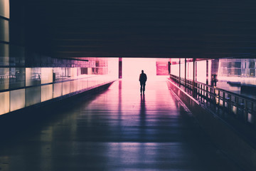 silhouette of a single person walking in    tunnel