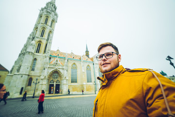 man taking selfie with old church on background