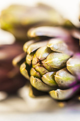 Fresh organic artichikes on marble table, selective focus