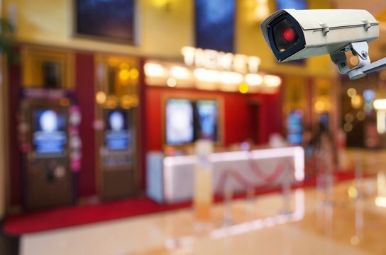CCTV, security indoor camera system operating with blurred image of ticket sales counter at movie theater, surveillance security and safety technology concept