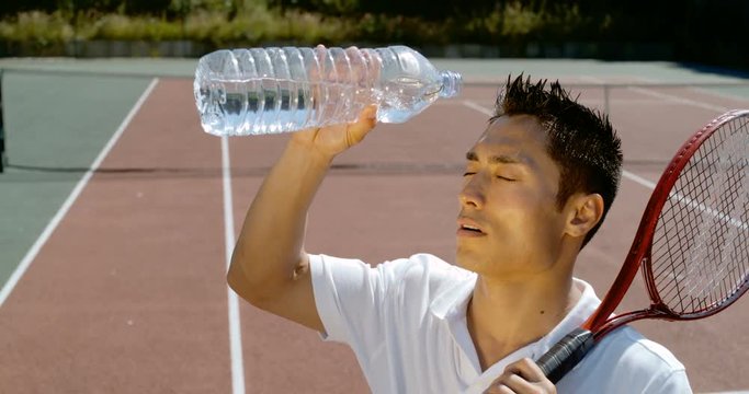  Super slow motion, male tennis player pouring water on his head to cool down.