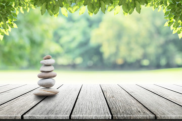 zen stones on empty wooden with green leaf in the garden background blurred and . Concept relaxation, zen, spring. 