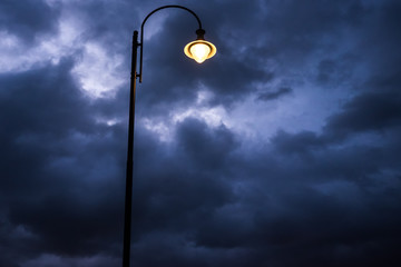 streetlight at sunset with dark clouds - winter time