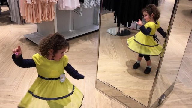 Cinemagraph of a little girl (age 03) dancing in front of a mirror. Real people. Copy space