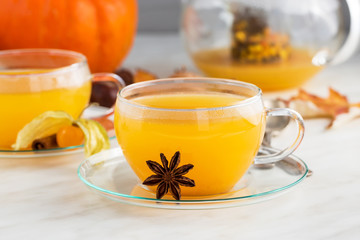 sea buckthorn tea with cinnamon and spices in beautiful glass cup. Natural light, selective focus. 