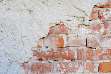 The wall of the old brick is partially covered with plaster