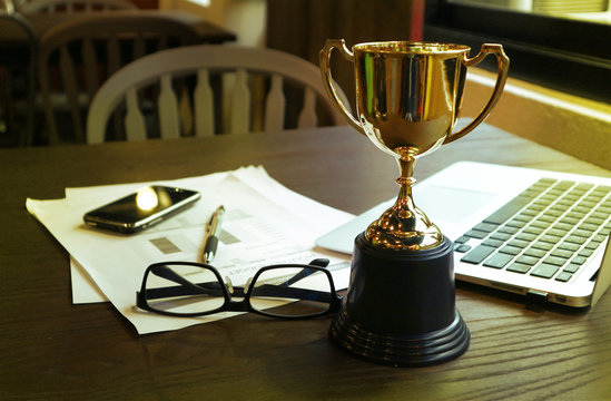 Trophy on work table, win concept