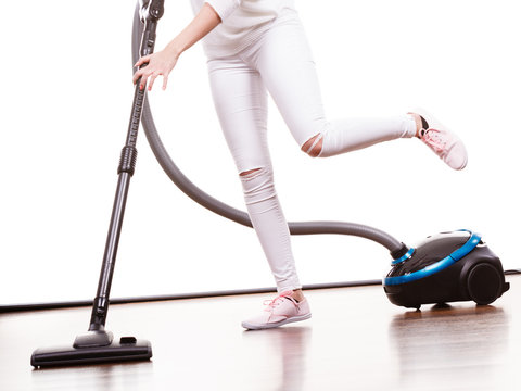Girl with vacuum cleaner on white