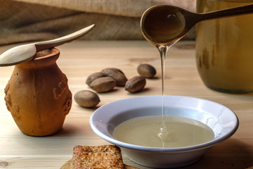 a plate and a jar of honey, wooden spoon dripping with honey
