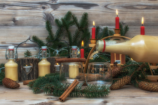Pouring egg liqueur out of a bottle. Festive Christmas alcoholic drink, cocktail in an atmospheric environment