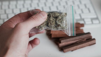 Bag with a marijuana in hand