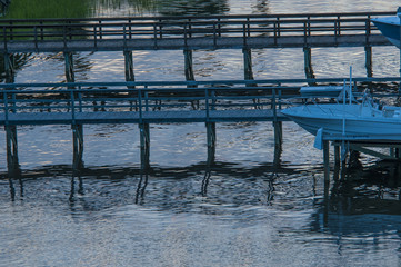 Boat waves ripple under a dock along the Inner Coastal Waterway, Oak Island, North Carolina.