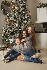 Mom with children on the background of a Christmas tree