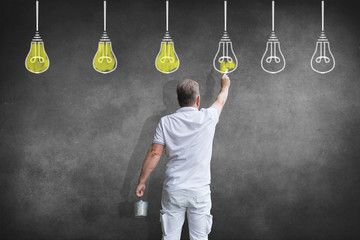 Ein Pfleger malt Gl&uuml;hbirnen als Konzept f&uuml;r Ideen