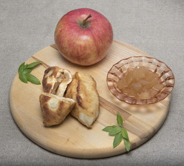 Apple theme. Ripe apple, jam, pies with jam on a cutting board and sackcloth
