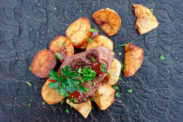 Tenderloin steak and fried potatoes with bbq sauce and parsley