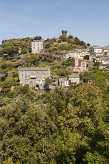 Fototapeta na wymiar Corsica, 28/08/2017: lo skyline di Nonza, villaggio sulla costa occidentale di Capo Corso, con le sue case antiche, i tetti e la sua torre genovese del XVI secolo