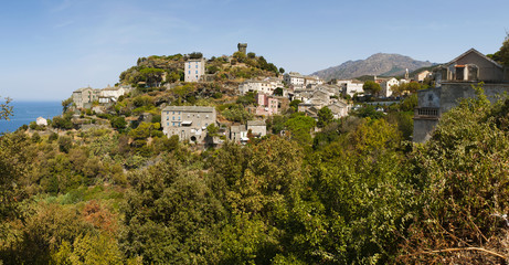 Corsica, 28/08/2017: lo skyline di Nonza, villaggio sulla costa occidentale di Capo Corso, con le sue case antiche, i tetti e la sua torre genovese del XVI secolo