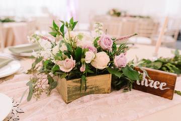 Wedding table decoration with flowers in rustic style