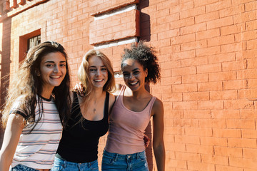 Portrait of three beautiful women on city street