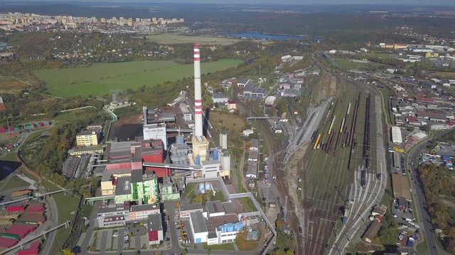 Flight over heating plant and thermal power station. Aerial view of combined modern power plant for city district heating and generating electrical power. Industrial zone with railway in the city.