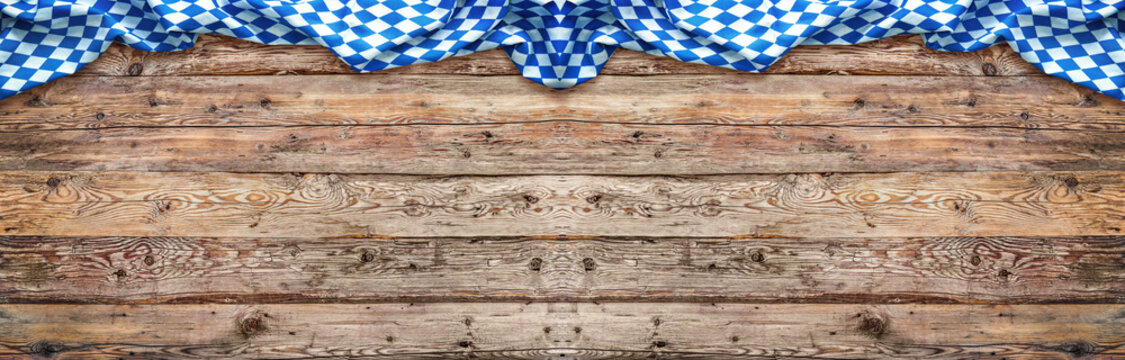 Rustic background for Oktoberfest with bavarian white and blue fabric on wooden